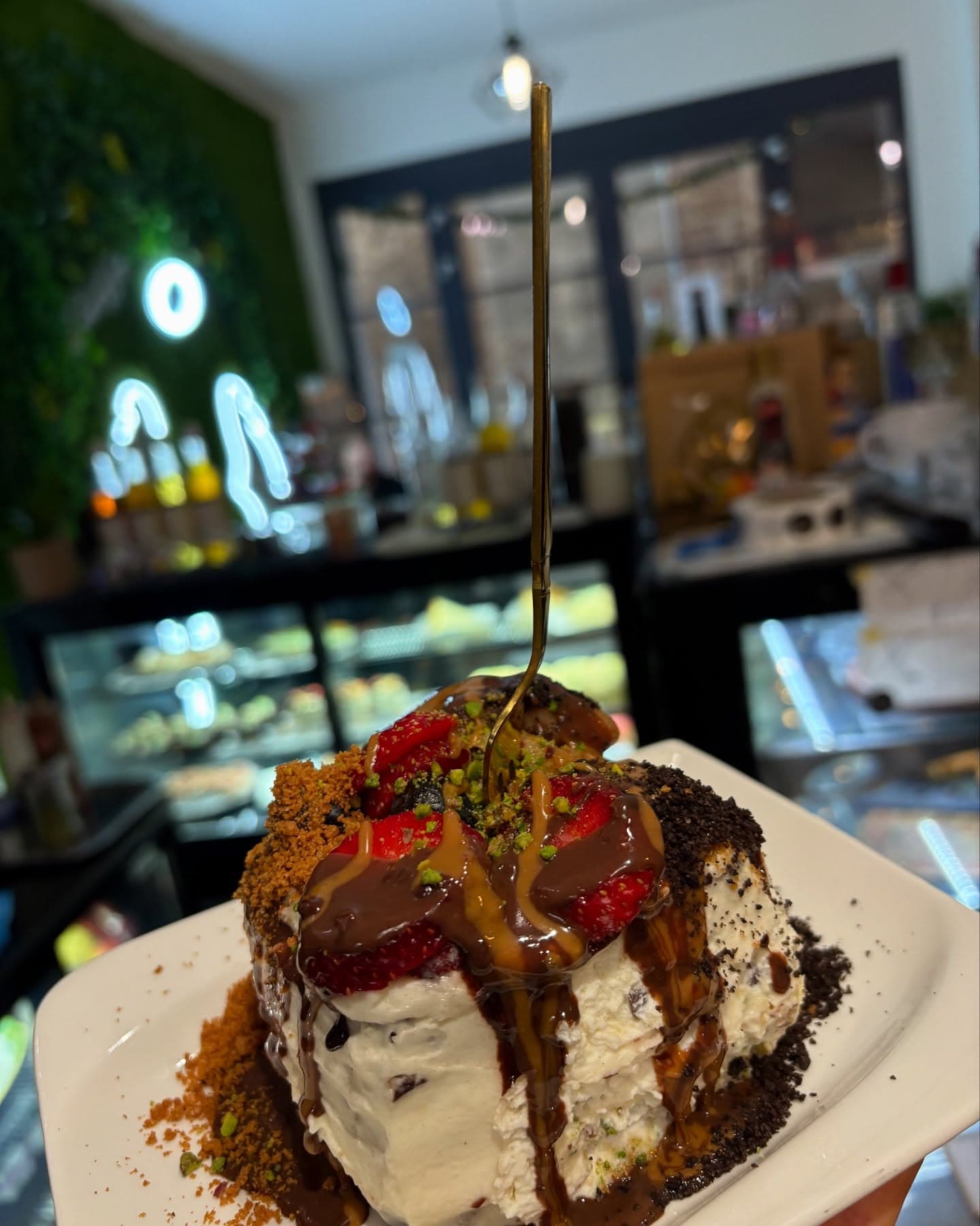 Milano Cake mit Schokoladensoße, Erdbeeren und Pistazien im Milano Café